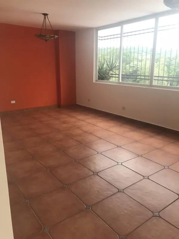 Spacious interior living room with large window, tile floors, bright lighting