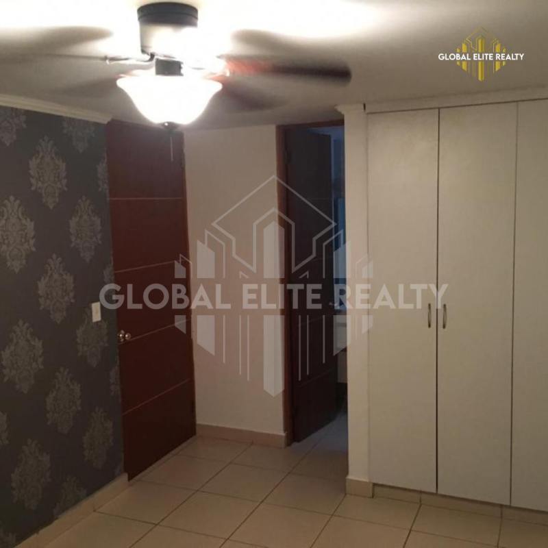 Bedroom with accent wall, built-in white wardrobe, tile flooring PH Pueblo Nuevo Panama