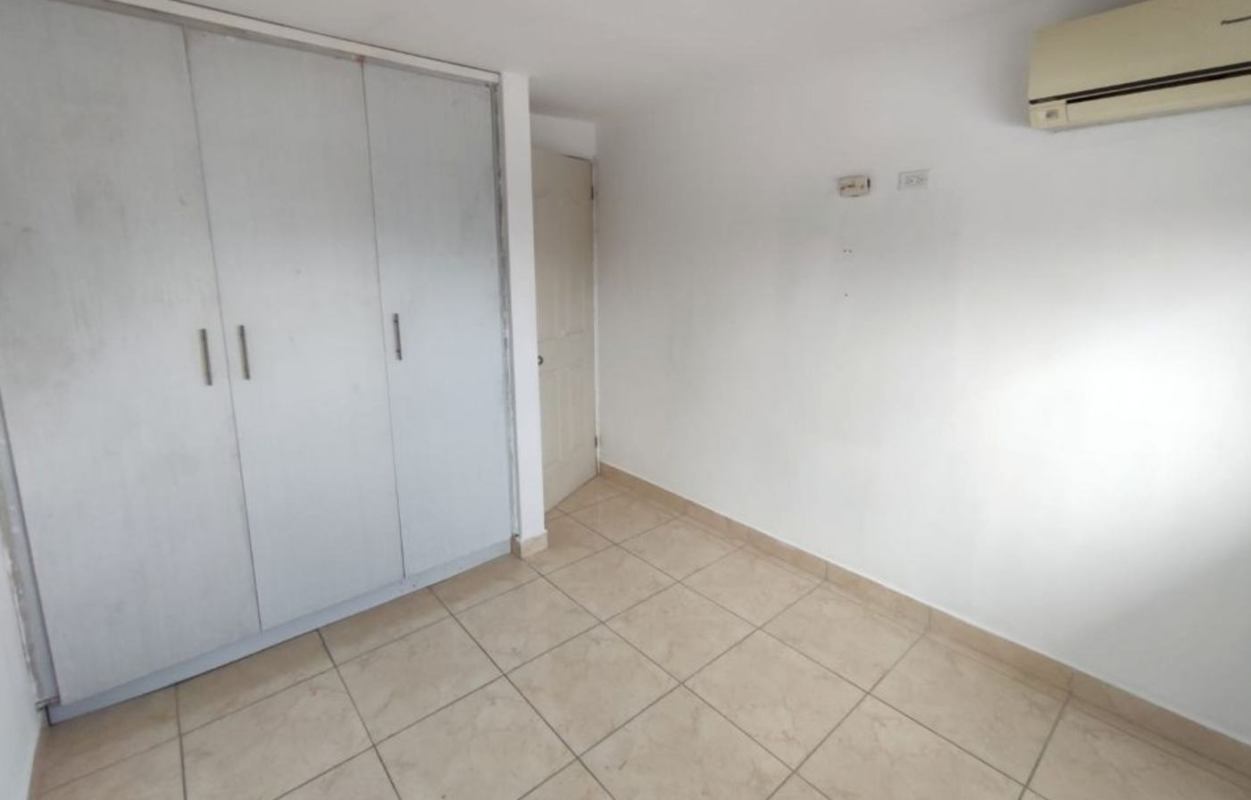 Empty white bedroom with tiled floor, built-in sliding wardrobe, AC PH Crystal Blue Panama City