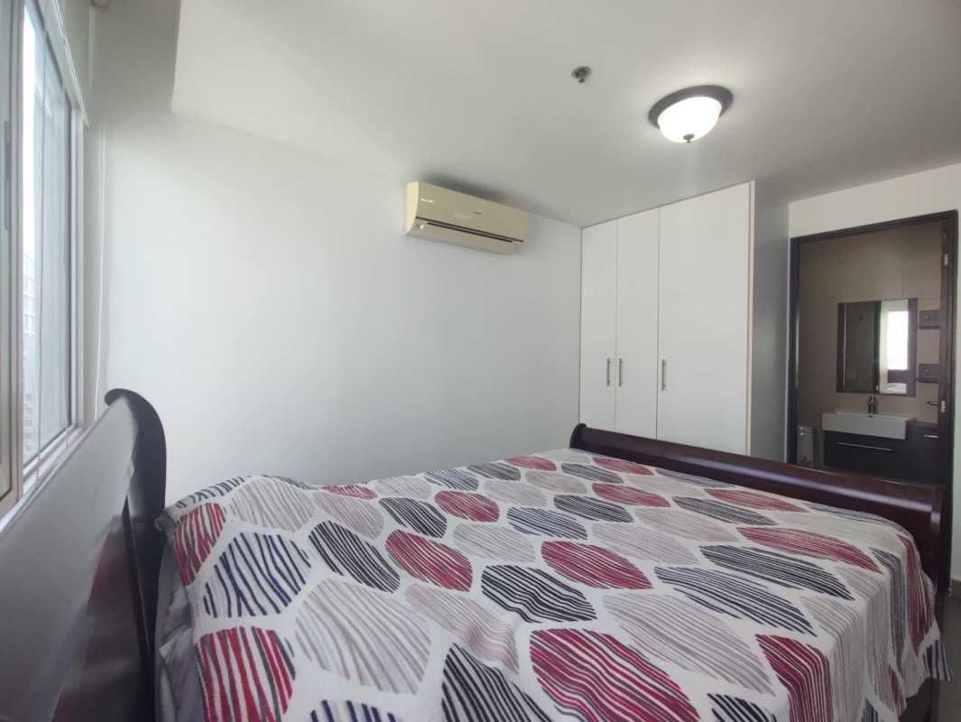 Bedroom with built-in wardrobe and large window city views PH Colores de Bella Vista Panama