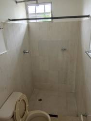 Minimalist bathroom with shower, sink and ceramic tiles in house Panama Oeste