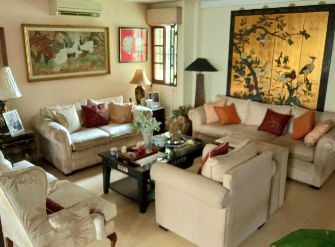 Traditional living room with cream sofas, Asian art, air conditioning San Miguelito house Panama