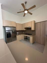 Kitchen with granite countertops, wood cabinetry, stainless appliances in Bijao Beach Club condo Panama
