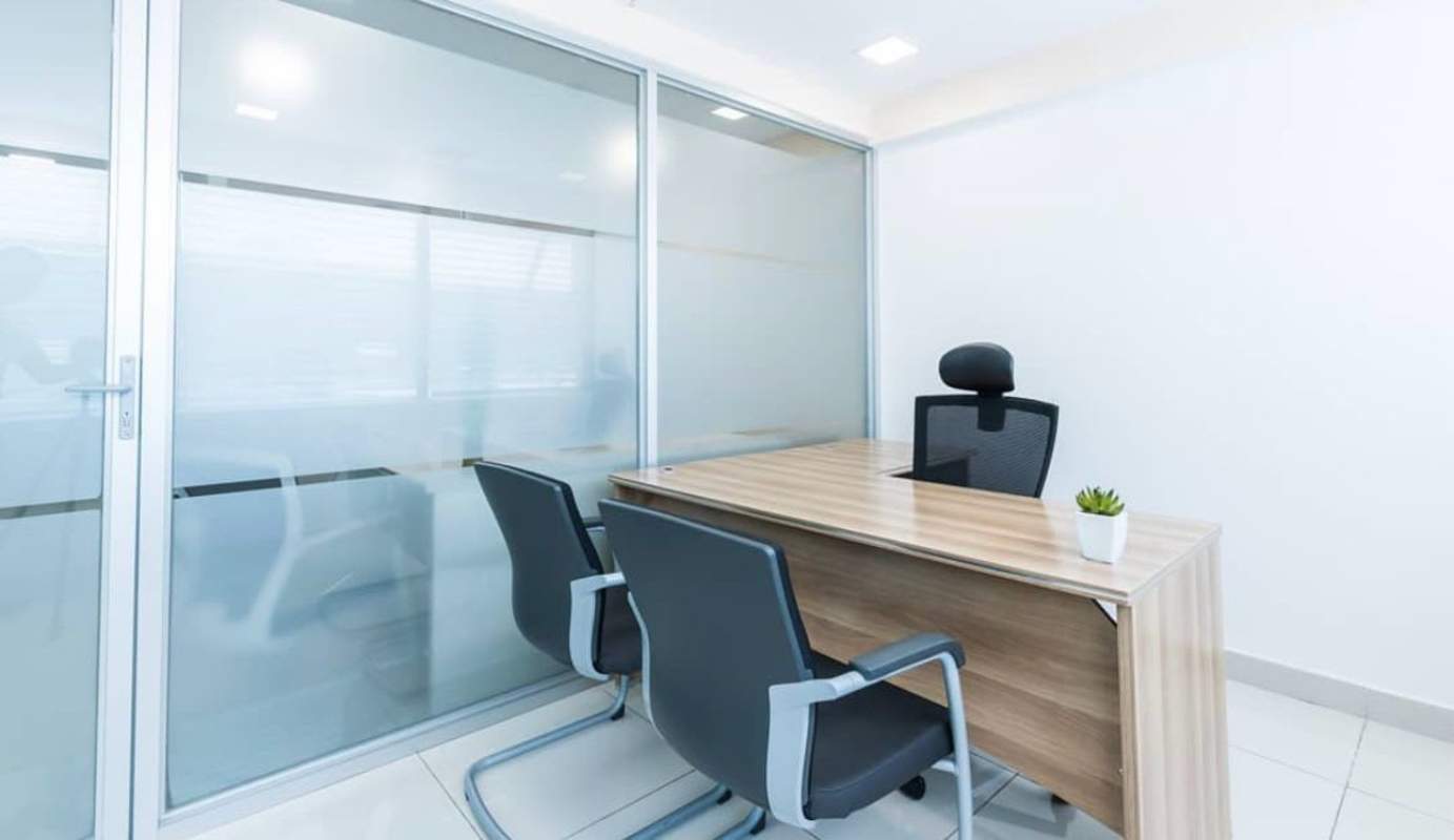 Private office with glass walls, wooden desk and black chairs Panama City
