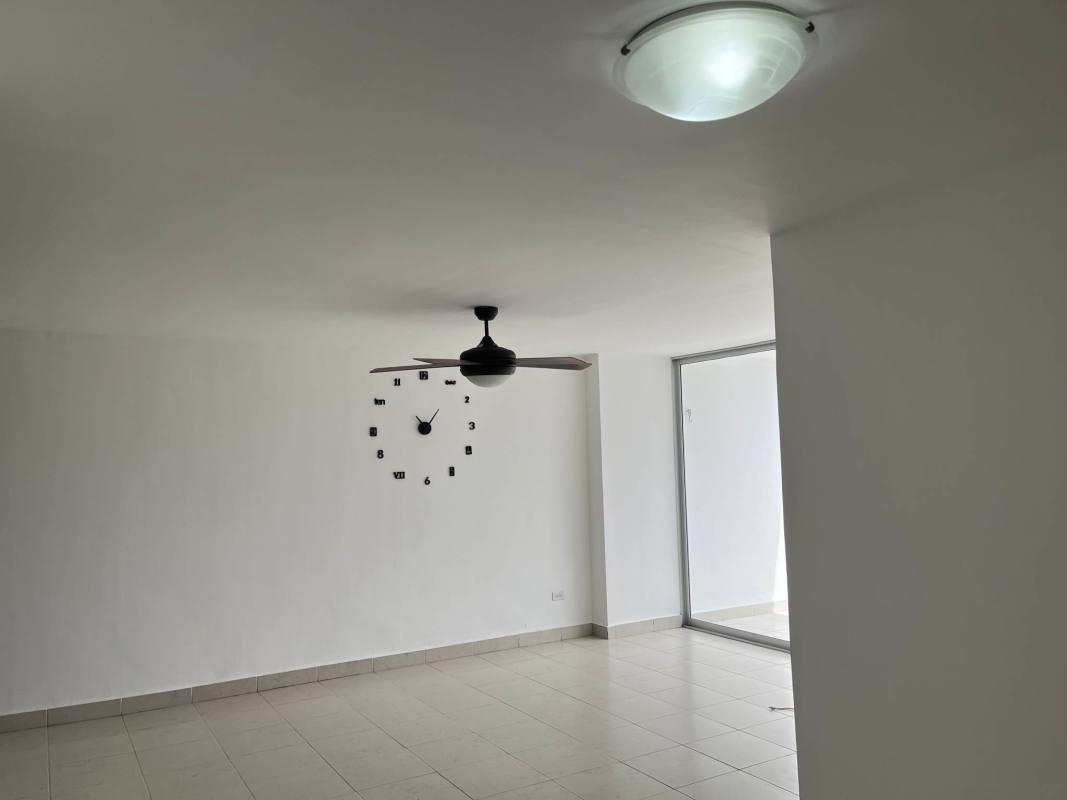 Bright living room with sliding glass doors leading to balcony overlooking city in PH Central Park Torre Tribeca