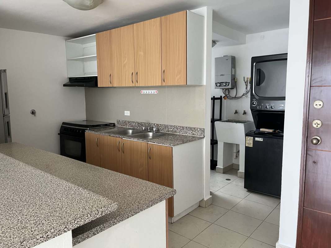 Kitchen with granite countertops, wooden cabinets, gas stove, laundry area with washer dryer in Central Park Tower Tribeca Panama