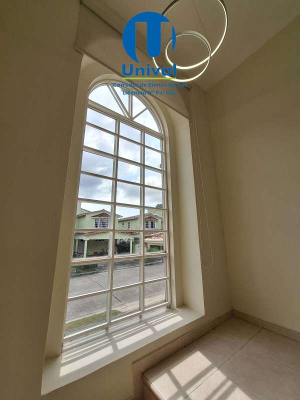 Staircase area with large arched window letting natural light inside Panama home