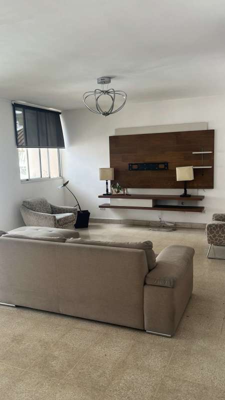 Living room with large windows, urban view, and modern furnishings in PH Via Argentina Panama 