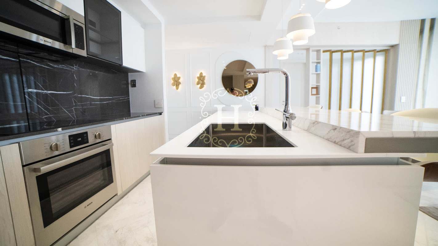 Modern kitchen with marble island, black backsplash, luxury appliances in PH Yacht Club Tower Panama