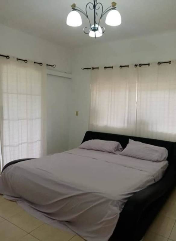 Minimalist bedroom with large bed, AC, light-filled windows overlooking gardens Cerro Azul Panama