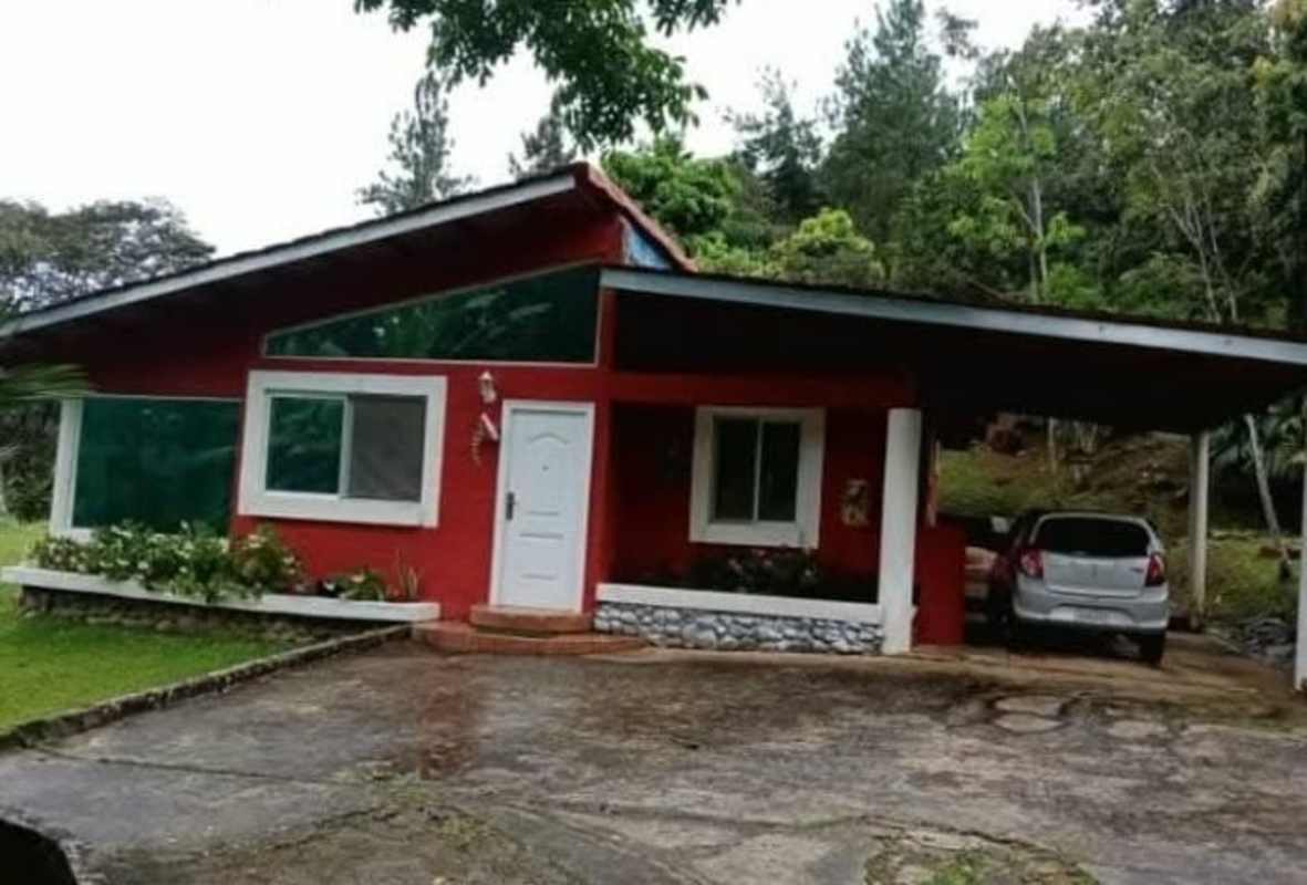 Bright rustic dining and living space with large windows, hammock in mountain house Cerro Azul