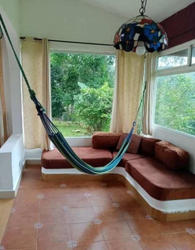 Bright enclosed terrace sun lounge with hammock overlooking gardens in Cerro Azul Panama