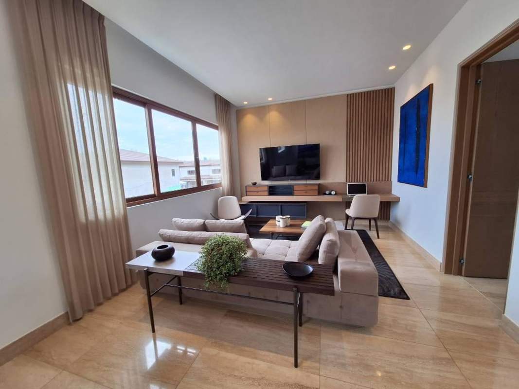 Bright upstairs living lounge with large windows, golf course views, modern decor in The Woods Panama