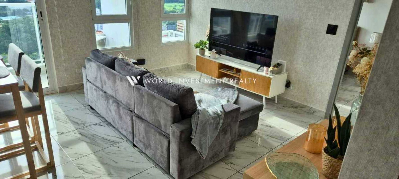 Living space with gray sofa, marble floors and windows in PH El Botánico Panama City