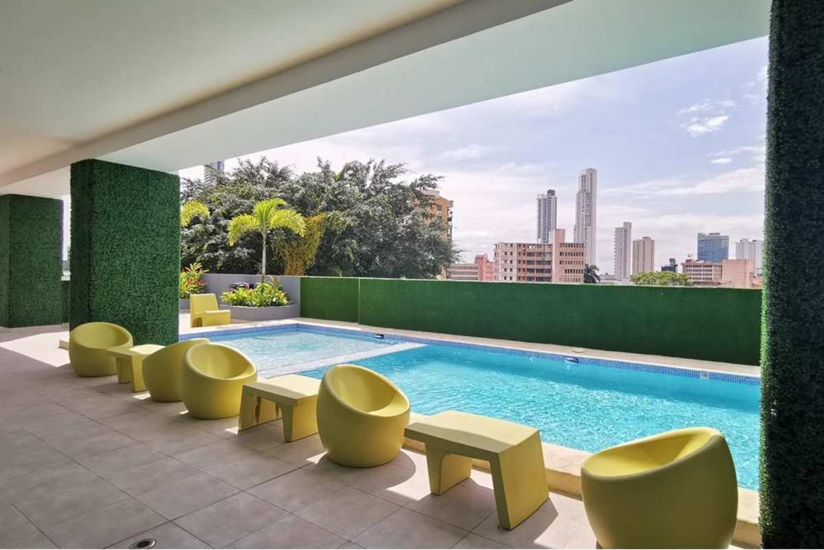 Panoramic window view of city and distant hills from PH El Botánico Panama
