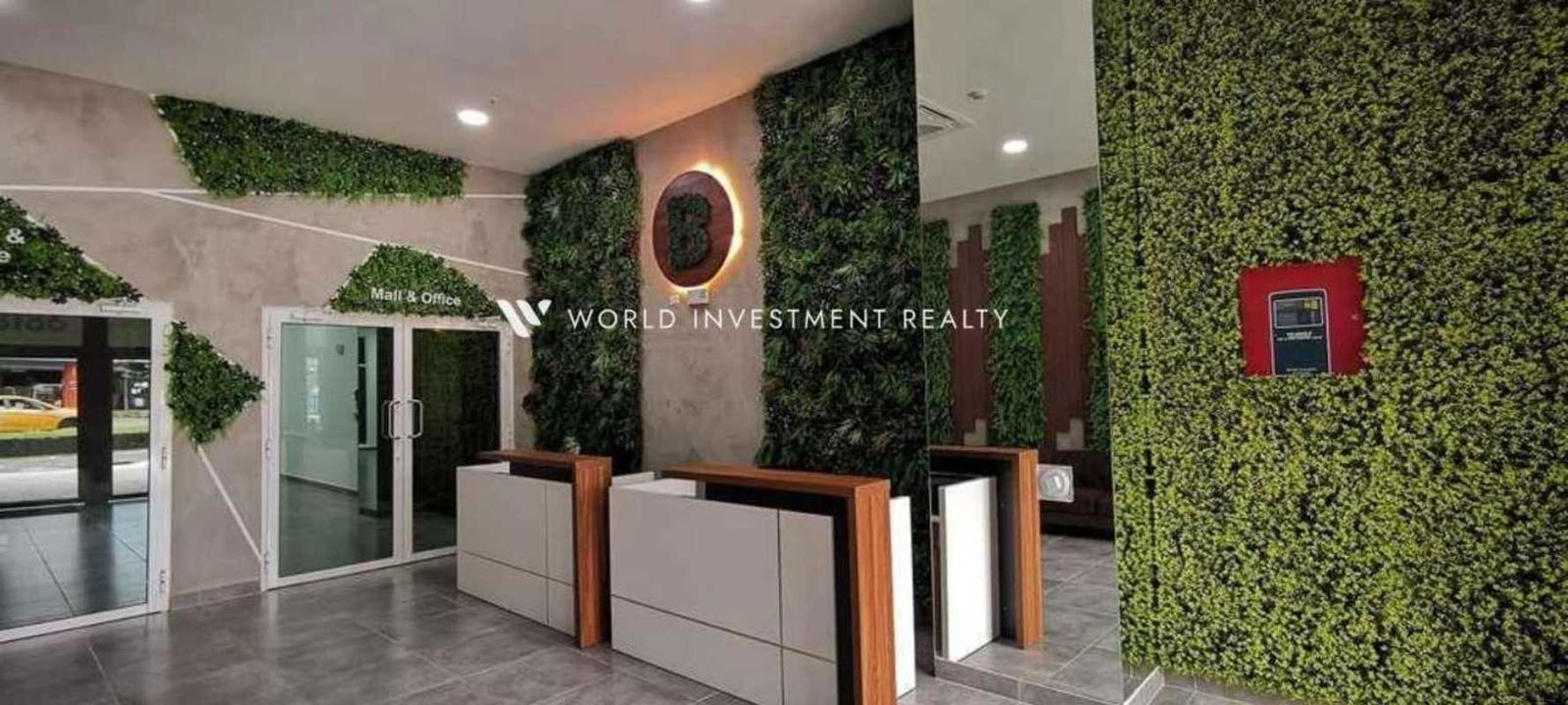 Lobby of PH El Botánico with green walls, reception desks and glass doors Panama City