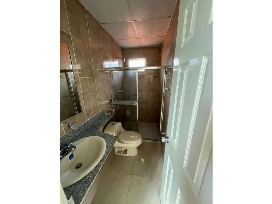 Bathroom with beige tiles, granite counter and glass shower enclosure in house at PH Colinas del Lago Panama