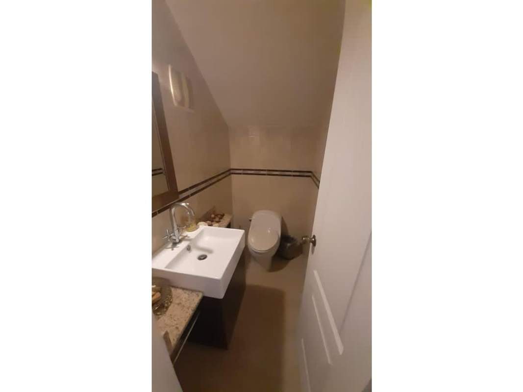 Luxury living room with leather sofas, open staircase, recessed lighting in Villa Valencia Panama