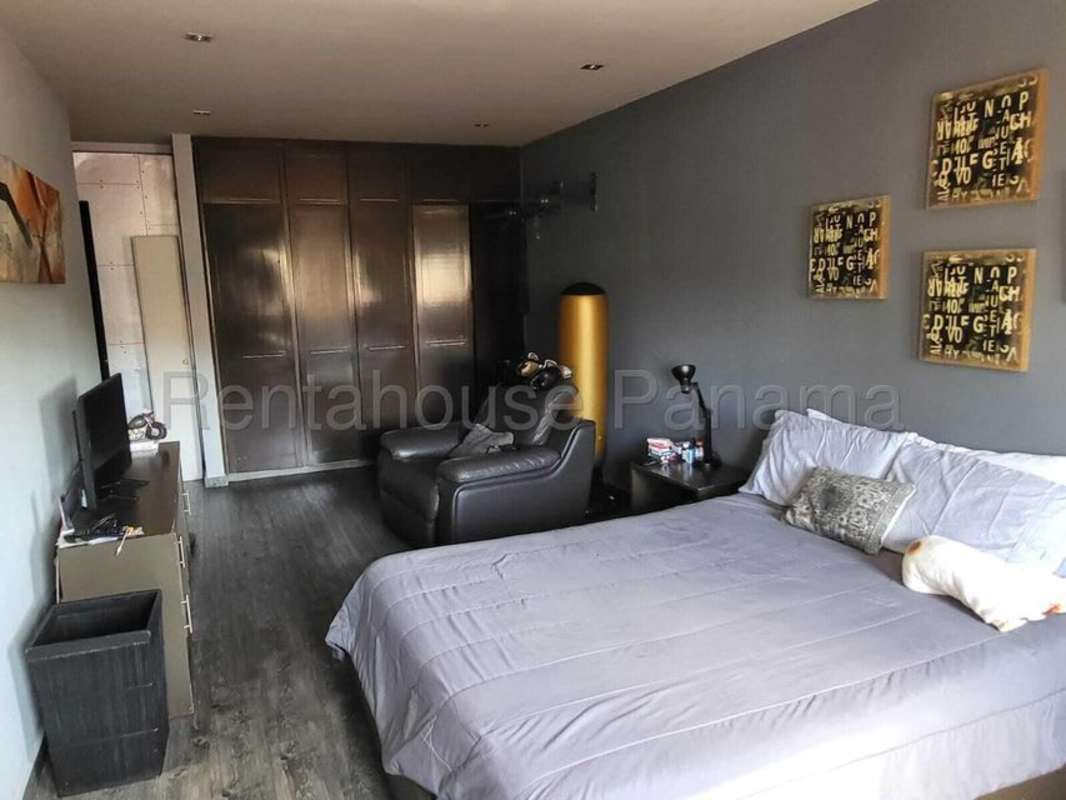 Spacious bedroom with balcony, wood floors, ceiling fan in El Carmen house Panama