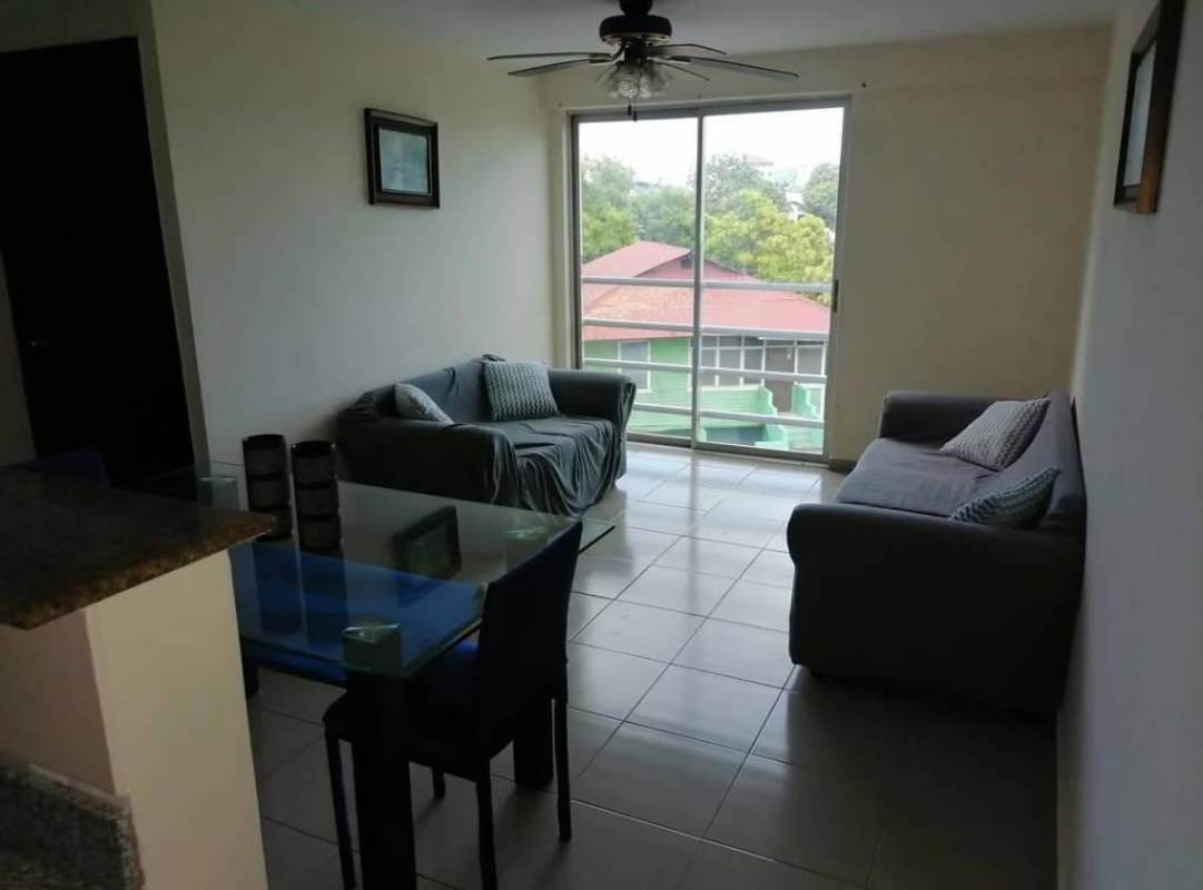 Dining area with glass table and blue chairs in budget-friendly Rio Abajo apartment for rent