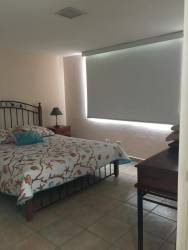 Bright bedroom with large covered window, neutral decor in PH Coronado Bay Panama