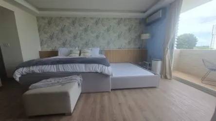 Open studio interior with king bed, living area and balcony in Playa Blanca Resort condo