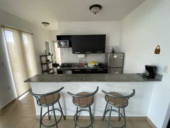 Minimalist kitchen with granite counter, stools, black cabinetry, stainless appliances Antón Coclé