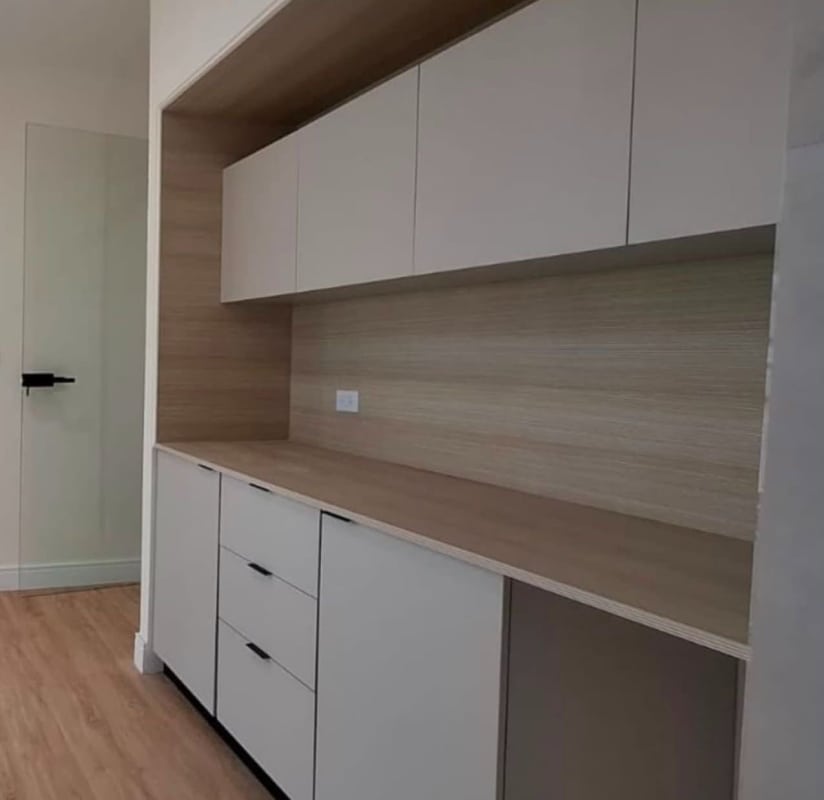 Compact kitchenette with wood backsplash and modern cabinetry inside office at PH BICSA Tower Panama City