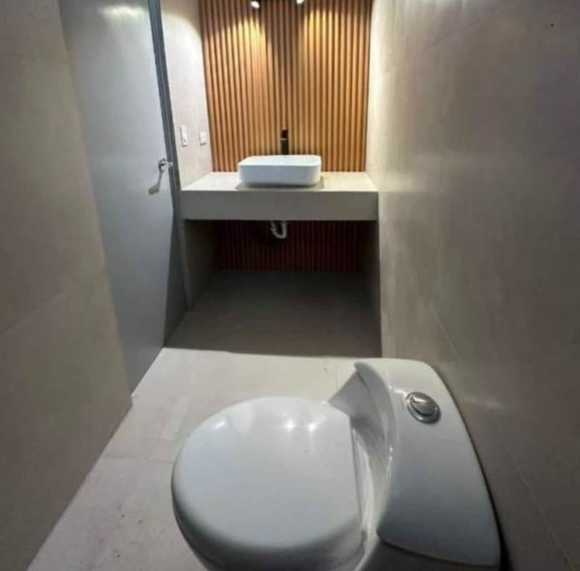 Minimalist clean bathroom with vessel sink and wood panel wall inside PH BICSA Tower Panama City