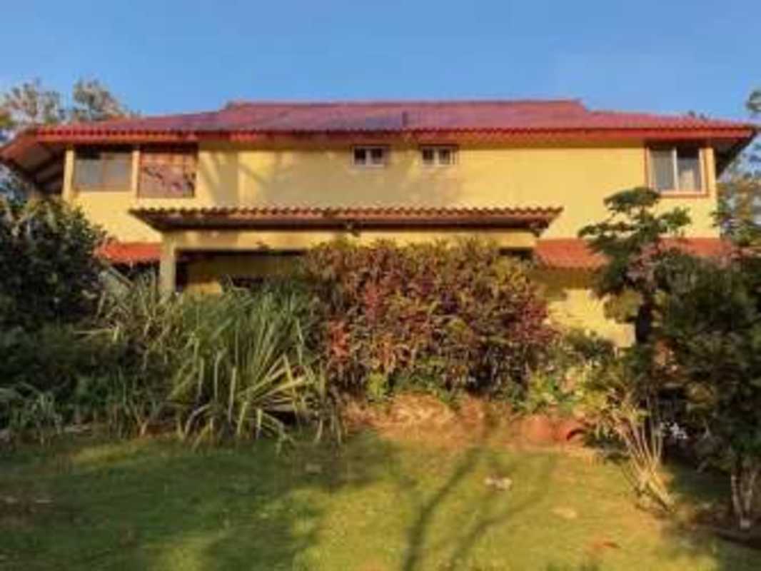 Mountain house living room with exposed beams brick fireplace tile floor in Panama