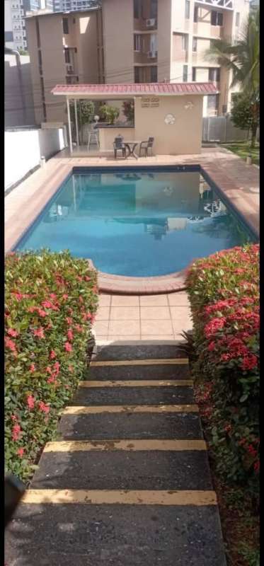 Three story apartment building facade with balconies purple accents near University of Panama