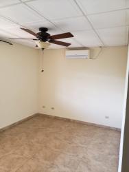 Bedroom with ceramic tile floor and ceiling fan, security window metallic grilles in Chitré house
