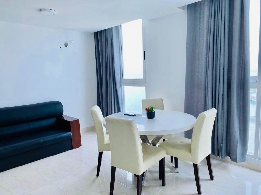 Curved glass balcony overlooking oceanfront and city skyline in Panama City Bella Vista Tower rental