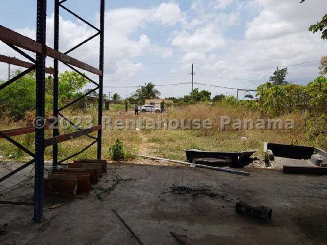 Open lot metal shed fence and open field industrial area Panama City