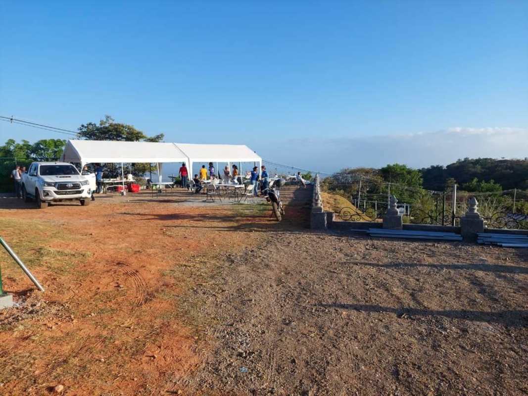 Outdoor gathering with tent trees vehicles on rural land Cerro Azul Panama