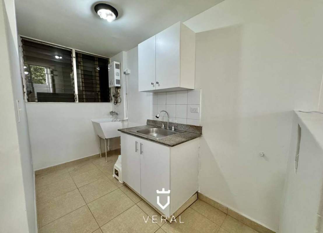 Laundry area with granite counter, utility sink, cabinets and window in PH Bella Vista Gardens apartment Panama
