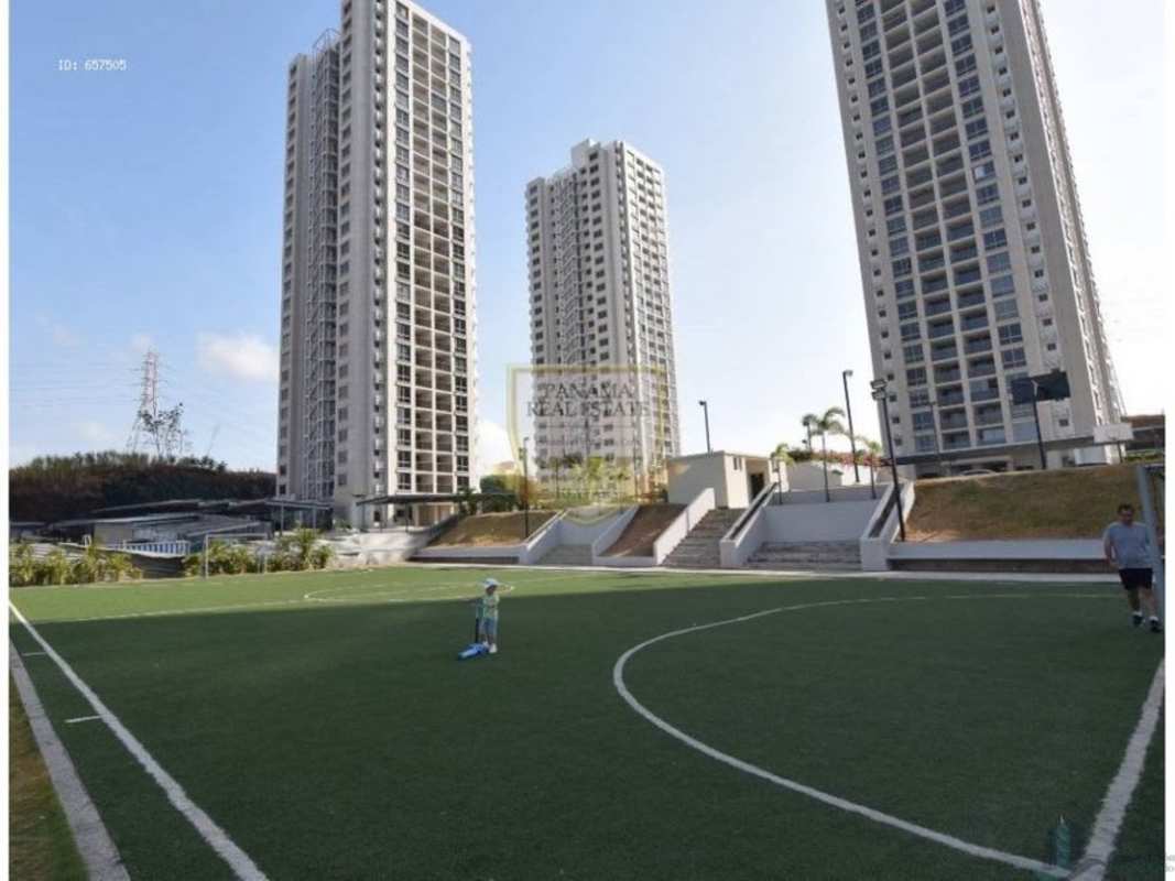 Colorful children's playground on artificial turf with high-rise towers at PH Rokas Condado del Rey Panama