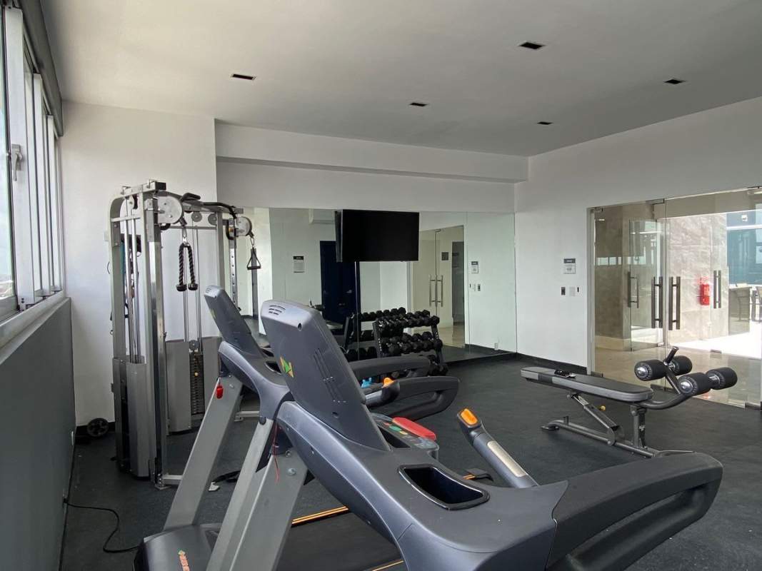 Swimming pool surrounded by apartment balconies and sun loungers in PH Rokas Panama City