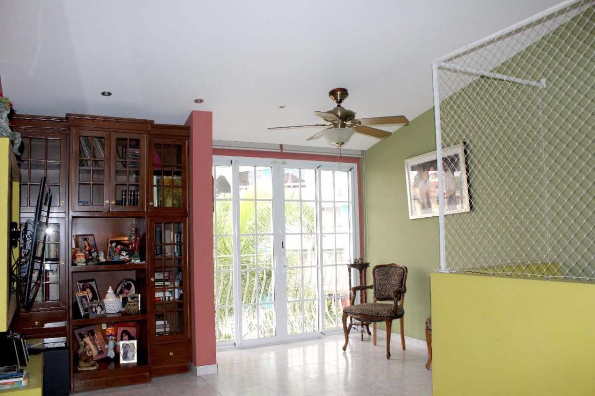 Bright living room with French doors to garden, patterned sofas, sheer curtains Betania Panama