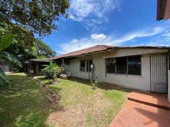 Aerial of two red-roofed buildings with tropical yard, estate Panama
