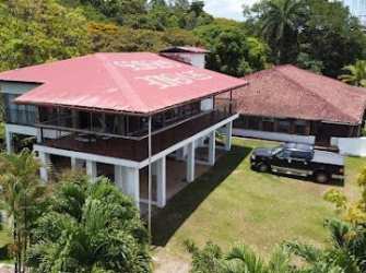 Aerial shot of estate with two buildings, lawn, ocean and mountain view Santa Rita Colón Panama