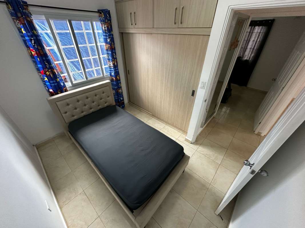 Bedroom with bed, built-in wardrobe, AC unit, window in PH Vallejo Panama City