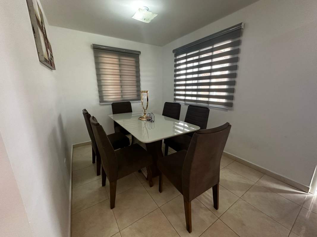 Modern dining area with six chairs, glass table, window blinds in PH Vallejo Panama