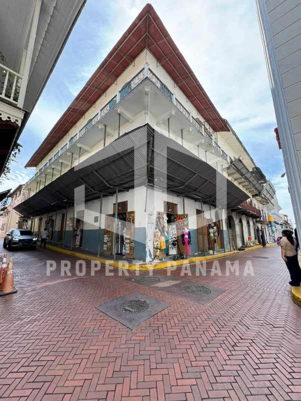 Colonial corner building with iron balconies and retail shops in Casco Viejo