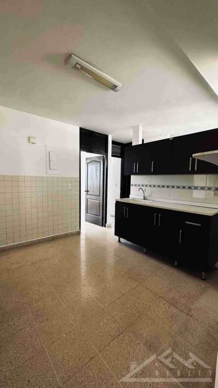 Minimalist kitchen with black cabinetry, white tile backsplash and appliances in Punta Paitilla