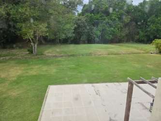 Extensive green lawn with shaded pergola and tropical backdrop Villa Royal Decameron Rio Hato Panama