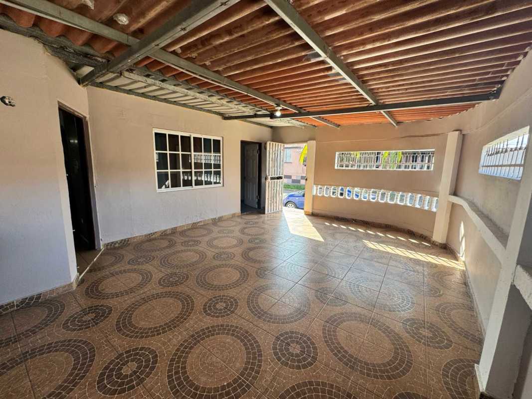 Spacious living room with tiled floor, accent wall, arched doorway in affordable Don Bosco home Panama City
