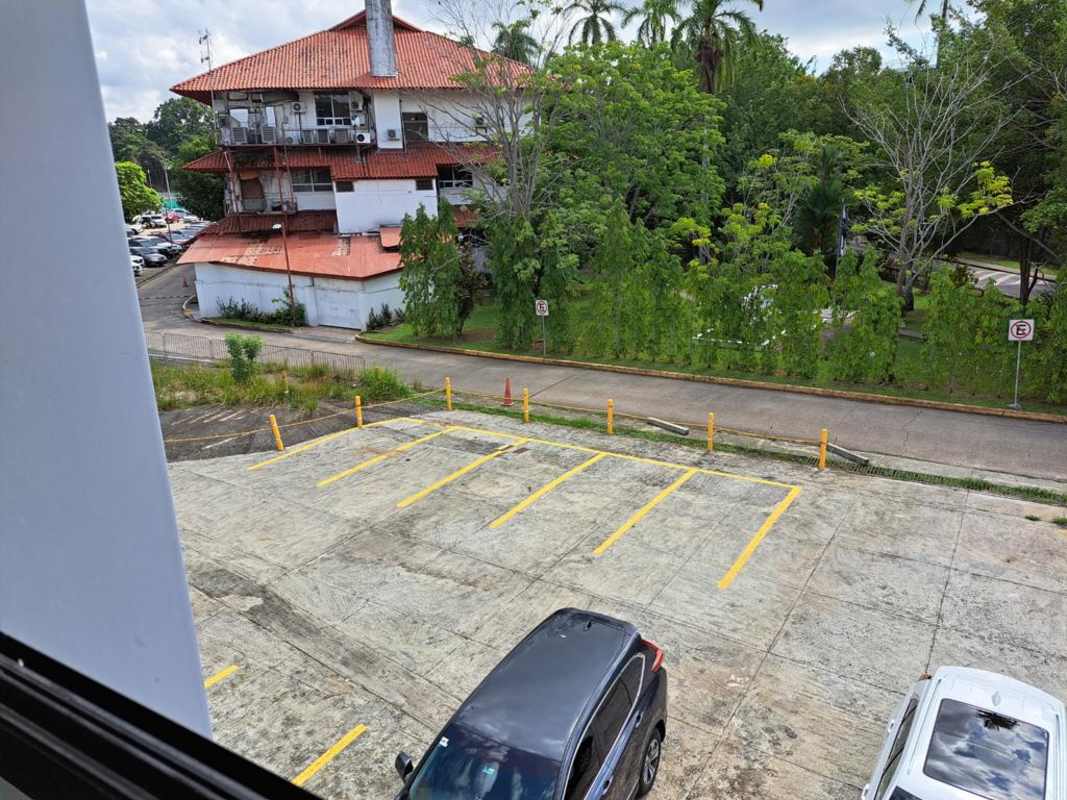 Concrete driveway access with parking and multi-story commercial building in Albrook near Clayton Panama