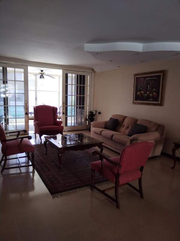 Spacious living area with large windows, ceiling fan, balcony access at PH Montecarlo El Cangrejo Panama