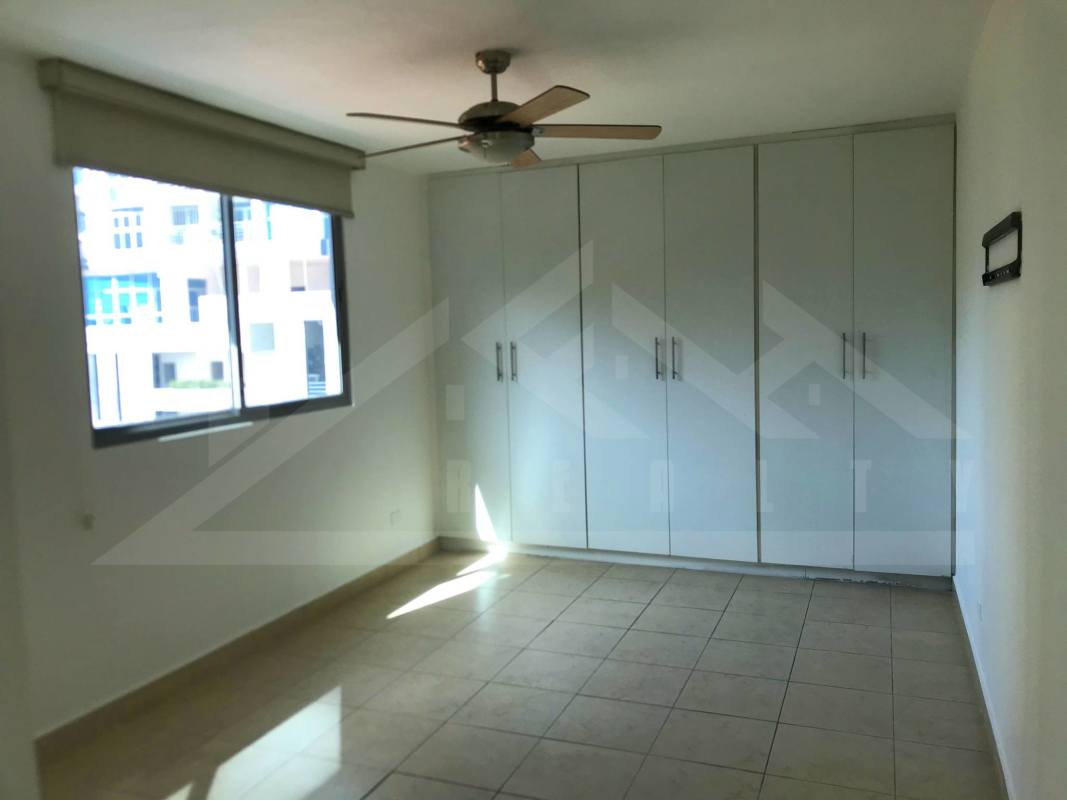 Bright bedroom with built-in wardrobe and ceiling fan in apartment Panama City Villa de las Fuentes